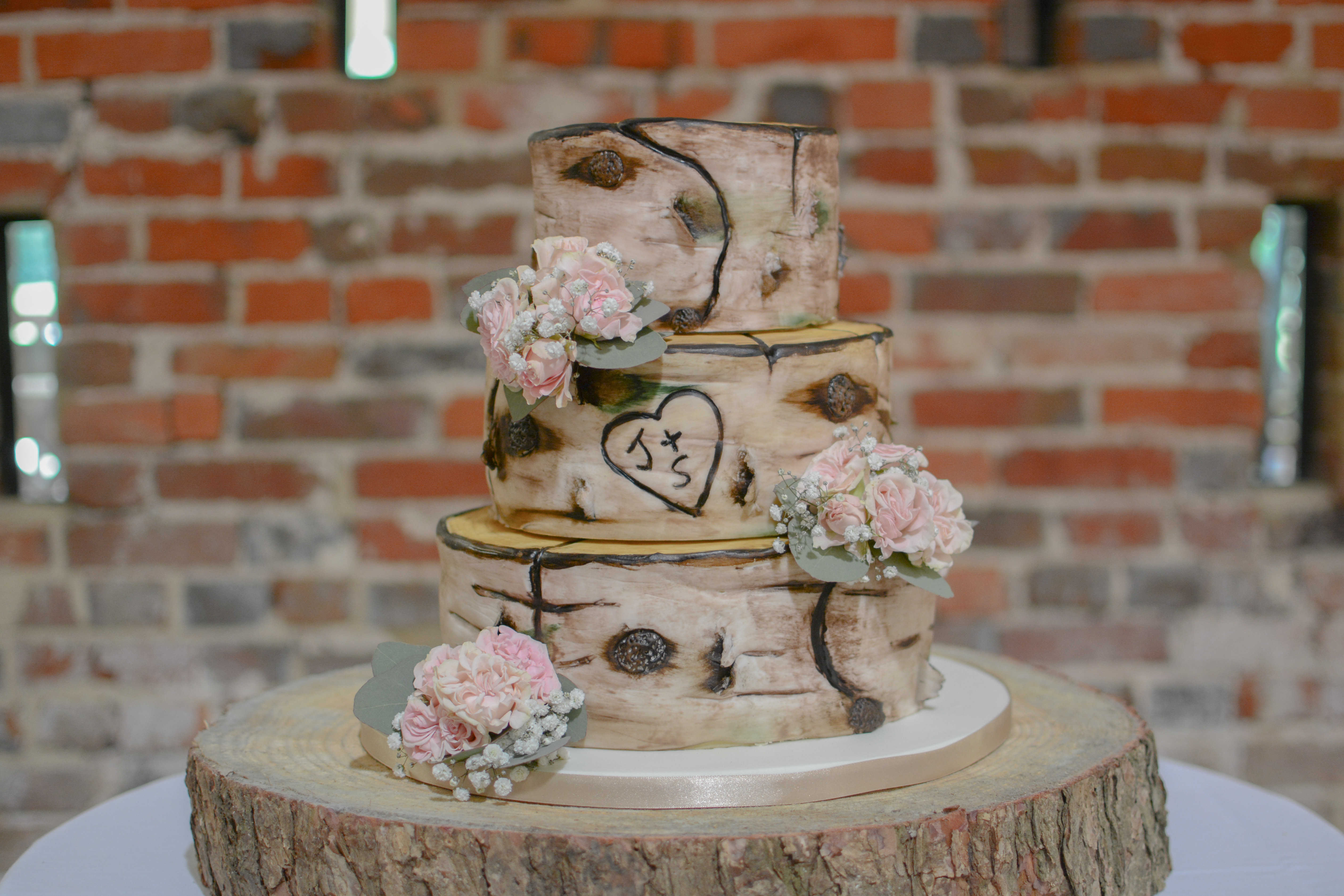 Three-tier birch bark wedding cake on a wood slice